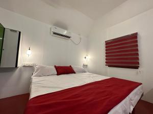 马拉利库兰Coastal Cabana Marari的一间卧室配有一张带红色毯子的床