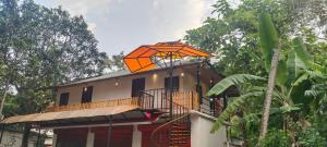马拉利库兰Coastal Cabana Marari的房子顶上的橙色伞