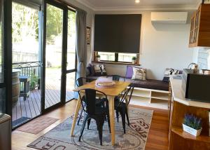 陶波The Nest - Relax & Unwind with Breathtaking Views over Lake Taupo的厨房以及带桌椅的起居室。
