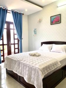Xa Dau GiayGreen Ville Hotel Đồng Nai的一间卧室配有一张带蓝色窗帘的大床
