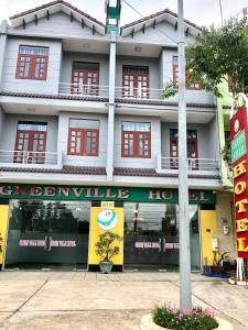 Xa Dau GiayGreen Ville Hotel Đồng Nai的建筑前方的商店,有红色的窗户