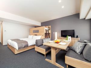 京都MIMARU KYOTO NISHINOTOIN TAKATSUJI的一间卧室配有一张床、一张桌子和一张沙发