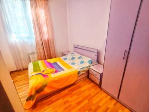 塞凡Sevan Island Cottage的小卧室配有一张带色彩缤纷的被子的床