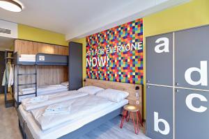 科隆MEININGER Hotel Köln West的一间卧室设有两张双层床和色彩缤纷的墙壁。