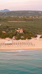 马拉松波利斯Lagouvardos Beach House的享有海滩和大楼的空中景致,配有椅子