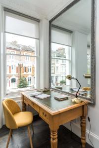 伦敦Stylish 2 bedroom at Hammersmith的一个带书桌和镜子的办公室