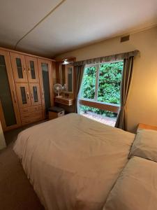 LawfordDedham Lodge的一间卧室设有一张大床和一个窗户。