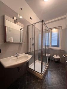 米兰帕尔马酒店的一间带水槽和淋浴的浴室以及两个卫生间