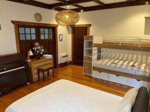 奥克兰Bayswater Homestay的客房设有两张双层床和一张书桌。