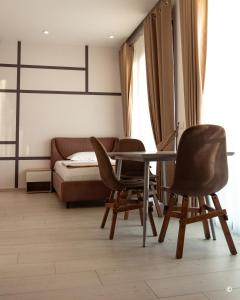 都拉斯Kronos Hotel的一间设有两把椅子、一张桌子和一张床的房间