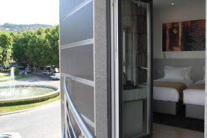 波塔莱格雷何塞雷吉奥酒店的阳台配有一张床,享有街道的景色