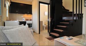 克里斯阿穆迪亚Maisonettes Athina的带沙发的客厅和通往厨房的楼梯