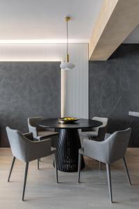 布加勒斯特Urbanstay Suites - Prime Location Designer Suite的一间用餐室,配有黑色的桌子和椅子