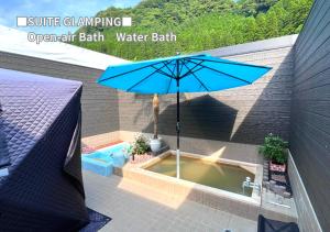 雾岛市Bihadanoyu Koshikano Onsen的露天浴池带雨伞的热水浴