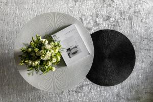 布加勒斯特Urbanstay Suites - Prime Location Designer Suite的一张桌子上花束的白色盘子
