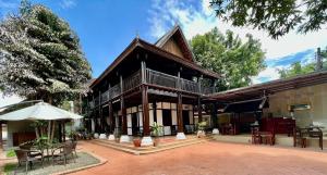 琅勃拉邦Villa Vieng Sa Vanh Hotel的一座带庭院的建筑,前面设有遮阳伞