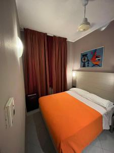 米兰帕尔马酒店的一间卧室,在房间内配有一张橙色的床