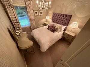 奥赫特拉德One Dunbar Court Gleneagles Village的一间带一张床和吊灯的小卧室