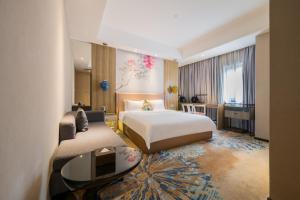 广州Paco Hotel Tаojin Metro Guangzhou-Free Shuttle Bus For Canton Fair的配有一张床和一张书桌的酒店客房