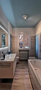 里乔内grande appartamento zona viale ceccarini con giardino的带浴缸、水槽和浴缸的浴室