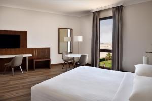 利雅德万豪酒店利雅得机场店的配有一张床、一张桌子和一张桌子的酒店客房