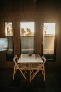 耶卢Nydelig moderne hytte på Geilo Kikut med høy standard - 4 senger 6 gjester的一个带两扇窗户的房间,配有一张桌子和椅子