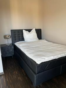 德累斯顿Luxury/Urban Penthouse的一张带黑色床头板和白色枕头的床