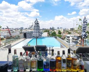 曼谷Ayathorn Bangkok的坐在游泳池前桌子上的一束瓶子