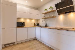 斯克拉斯卡波伦巴RentPlanet - Apartament Bawaria的厨房配有白色橱柜和微波炉