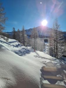 伊索拉2000Chalet Marano Restaurant & Spa的山上闪烁着阳光的雪覆盖的斜坡
