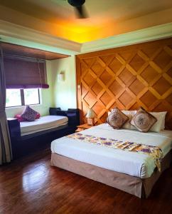 珍南海滩Langkawi Lagoon Resort Seaview的一间卧室设有一张大床和一个木制床头板