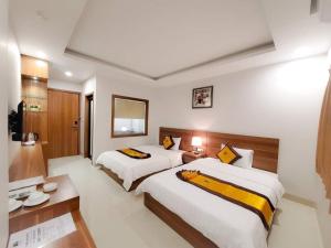 下龙湾Tuấn Linh Hotel的酒店客房配有两张床和一张书桌