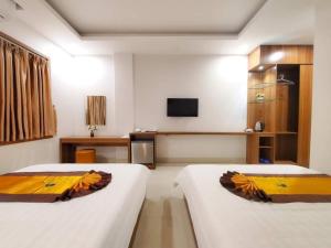 下龙湾Tuấn Linh Hotel的酒店客房设有两张床和电视。