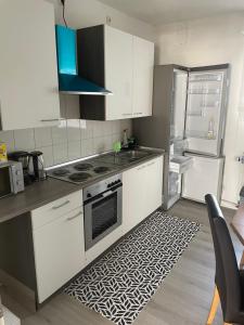 卡塞尔Ferien - Wohnung In Kassel Waldau Zentral的厨房配有白色橱柜、炉灶和冰箱。