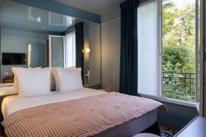 巴黎Hôtel La Conversation的一间卧室设有一张床和一个大窗户