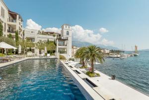 蒂瓦特Porto Montenegro的水边建筑物前的游泳池