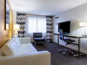 巴尔的摩Comfort Inn & Suites Baltimore Inner Harbor的酒店客房设有沙发、书桌和电脑
