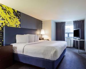 巴尔的摩Comfort Inn & Suites Baltimore Inner Harbor的酒店客房设有一张大床和一台电视。