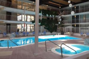 拉法叶Quality Inn West Lafayette - University Area的大型建筑内的大型游泳池,配有桌椅