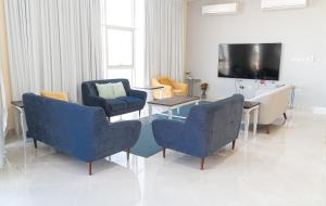 Al Faq‘مزرعة واستراحة الفقع的客厅配有椅子、桌子和电视