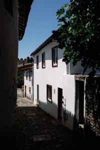 布拉干萨Casa do Javali的一条有白色建筑和树的小巷