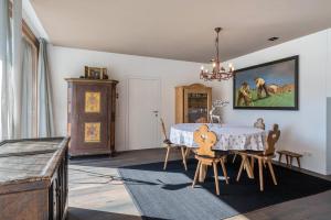 坎波图雷斯Mountain Chalet Obertreyen的一间带桌椅和绘画的用餐室