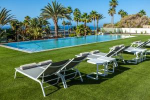 圣阿古斯丁Abora Interclub Atlantic by Lopesan Hotels的游泳池旁的一排桌椅