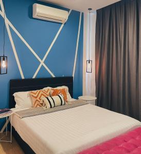 东贡岸ITCC Manhattan Suites by Pleasant Amenities的一间卧室配有一张蓝色墙壁的床