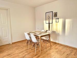 纳尔瓦CityHeart Economy Nook的一间带桌子和白色椅子的用餐室