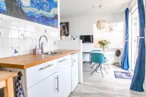 阿姆斯特丹The New Lake Boathouse的厨房配有白色橱柜和蓝色椅子