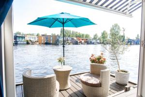 阿姆斯特丹The New Lake Boathouse的一个带椅子和遮阳伞的庭院