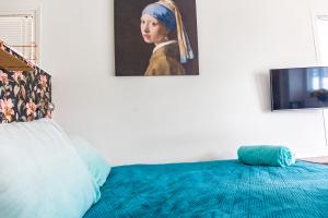 阿姆斯特丹The New Lake Boathouse的卧室配有一张带女性绘画的床