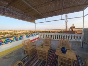 阿斯旺Private House with Garden and terrace in Aswan的屋顶上带桌椅的天井