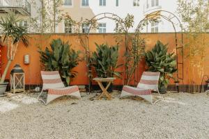 萨尔茨堡arte vida boutique guesthouse的庭院里种有植物,配有四把椅子和一张桌子